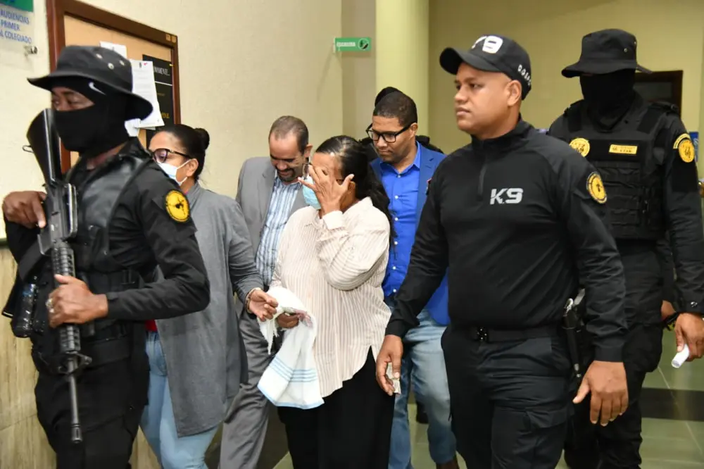 Imputada en Caso Senasa 2.0 se tapa la cara con la mano  mientras recorre pasillos de del tribunal.  Olga Vergés.