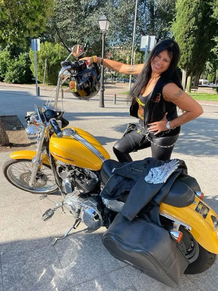 María Espinosa Feliz posa funto a una motocicleta. Fuente externa.