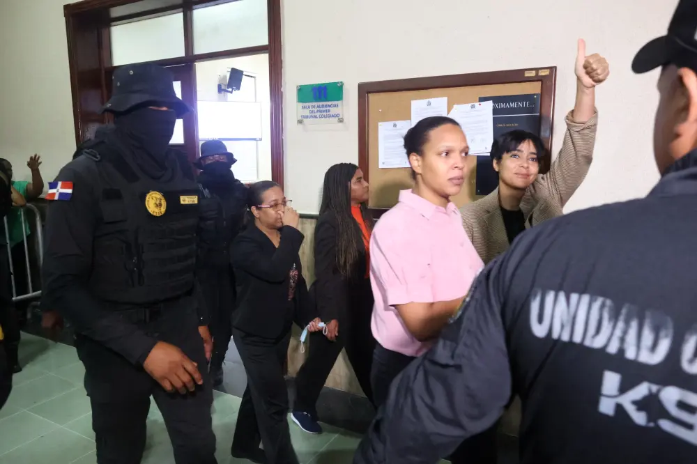 Una de las imputadas en el Caso Senasa 2.0 celebra decisión del juez levantando la mano. Olga Vergés.