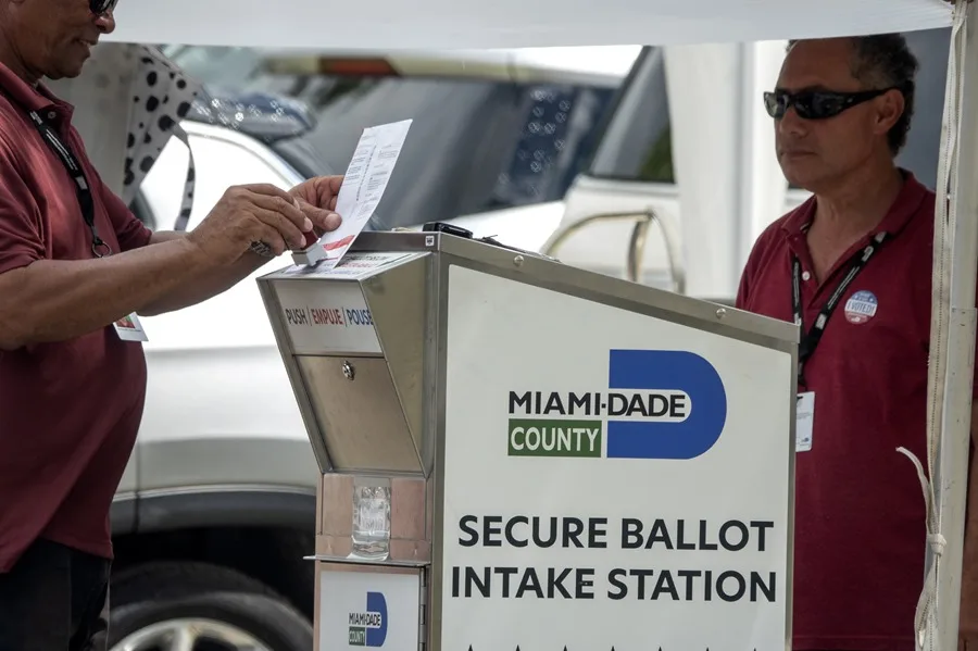 Fotografía de archivo de los funcionarios electorales ayudando a votantes a depositar su boleta de voto por correo en el buzón oficial de votación. EFE/ EPA/ Cristóbal Herrera-Ulashkevich