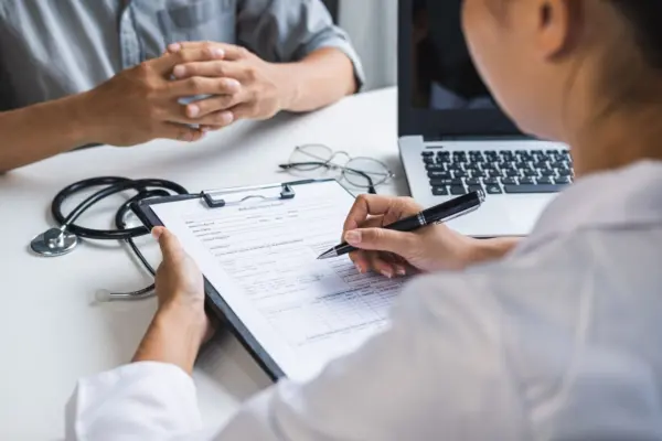 medico-profesional-que-consulta-su-paciente-en-el-hospital-concepto-de-salud-scaled