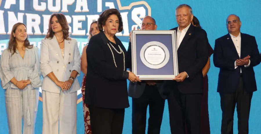 Leonardo Aguilera Batista, de  Banreservas, entrega a la señora Ela Sued, viuda de  Héctor José Rizek Llabaly.  Alberto Calvo.