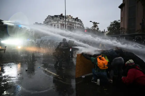 Manifestantes se enfrentan al cañón de agua de la policía cerca de la Porte de Vincennes, en París, durante una protesta el 24 de octubre de 2026.AFP