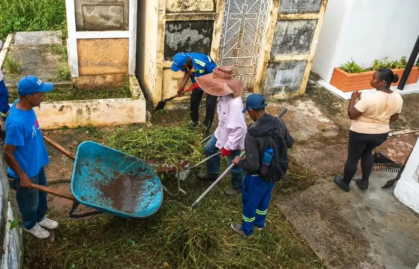 Obreros de la alcaldía en plena labor en un cementerio.