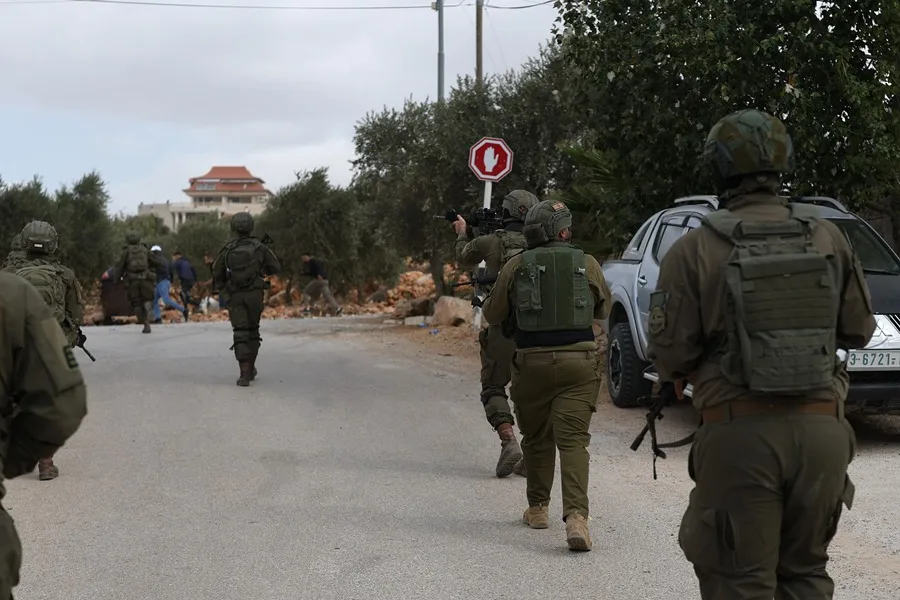 Soldados israelíes permanecen de pie tras un ataque de colonos contra familias que cosechaban sus olivos en Abu Falah, Cisjordania. EFE/EPA/ATEF SAFADI/ Archivo