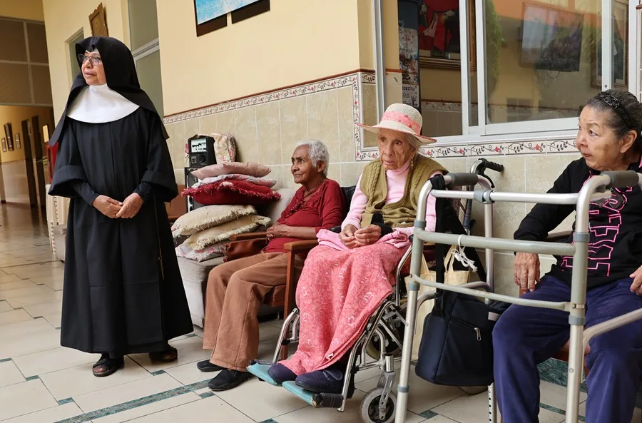 Una religiosa camina junto a adultos mayores en la casa asilo de las Hermanitas de los Ancianos Desamparados, en el Callao (Perú). EFE/ Paolo Aguilar