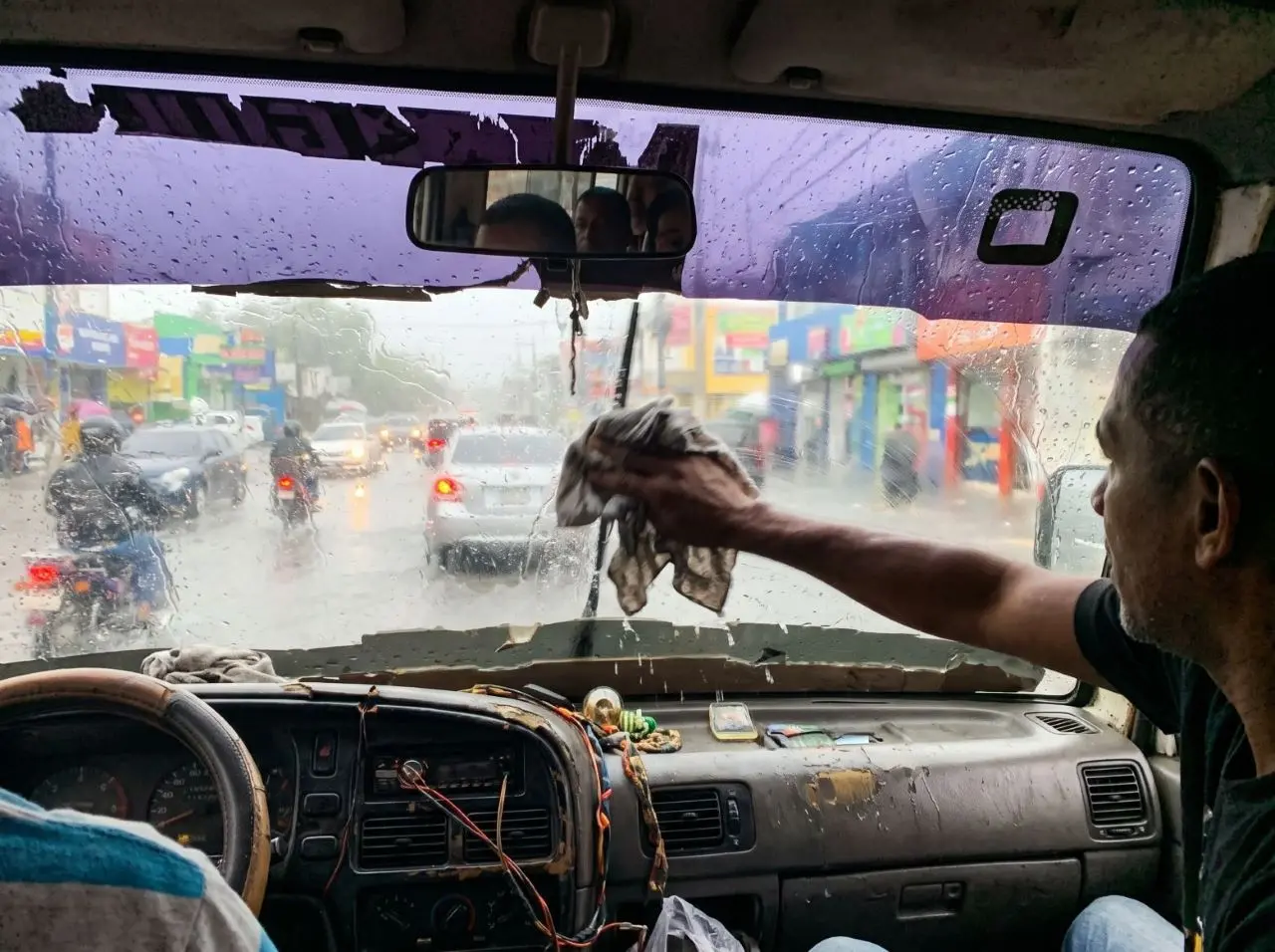 Guaguas públicas usan paños para limpiar los cristales en medio de las lluvias