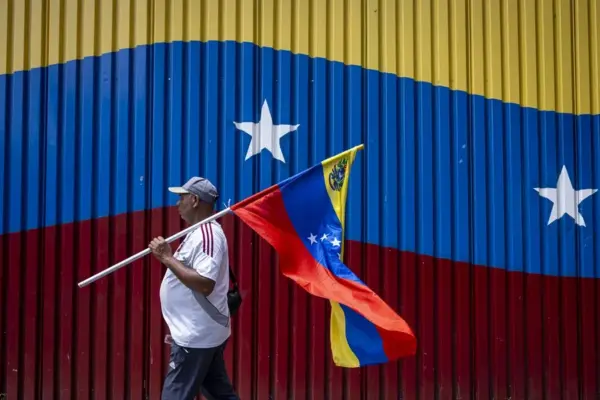 Un hombre camina con la bandera de Venezuela. EFE/Miguel Gutiérrez/Archivo